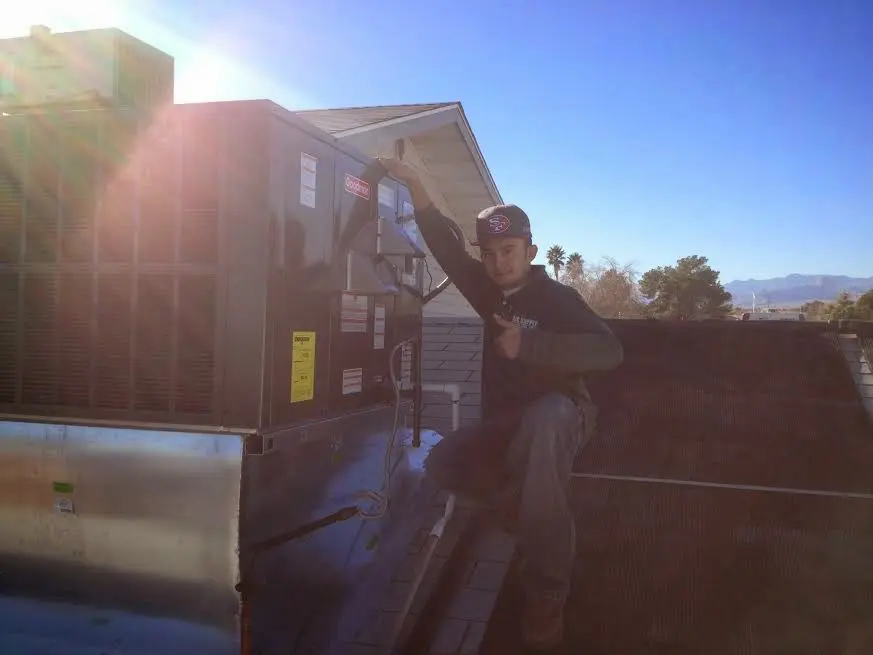 HVAC technician performing AC Tune-Up on a rooftop unit in Cherry Hill